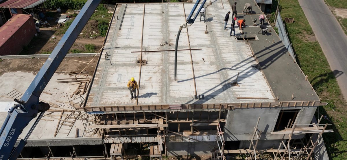 Kraan hijst een betonnen element op de bouwplaats